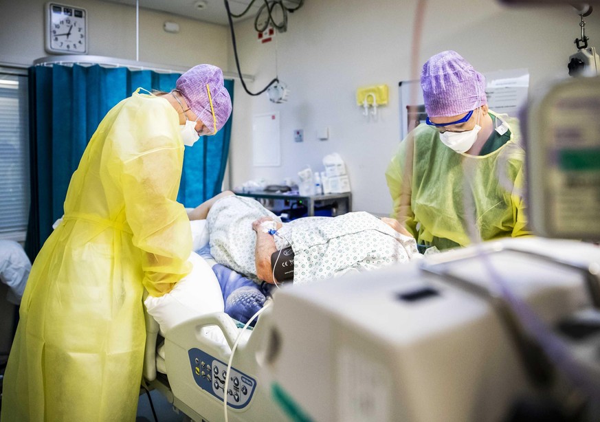 Pflegekräfte betreuen einen Patienten auf der Intensivstation (Symbolbild)