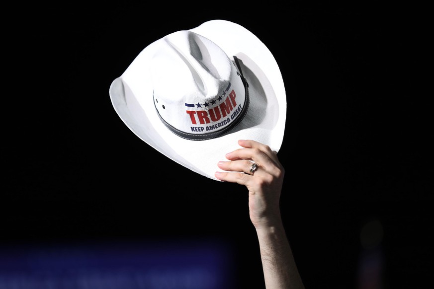 OPA LOCKA, FLORIDA - NOVEMBER 01: A cowboy hat is held up as people wait for the arrival of U.S. President Donald Trump for his campaign event at Miami-Opa Locka Executive Airport on November 1, 2020  ...