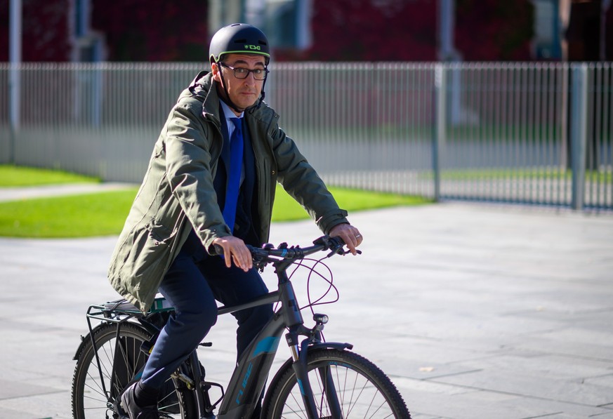 12.10.2022, Berlin: Cem Özdemir (Bündnis 90/Die Grünen, l), Bundesminister für Ernährung und Landwirtschaft, fährt mit dem Fahrrad nach einem Pressestatement anlässlich der Kabinettsfassung zur Tierha ...