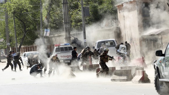 Security forces run from the site of a suicide attack after a second bombing in Kabul, Afghanistan, Monday, April 30, 2018. A coordinated double suicide bombing hit central Kabul on Monday morning. Mo ...