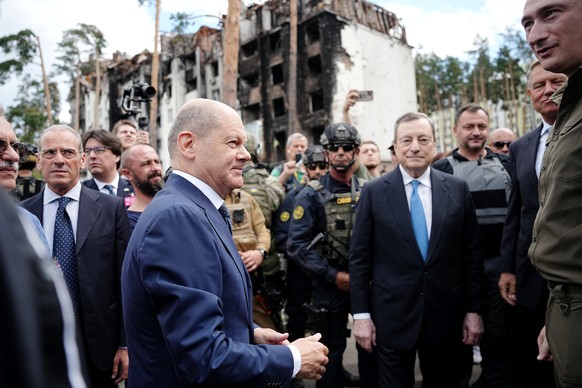 Bundeskanzler Olaf Scholz (vorne, SPD) geht mit Mario Draghi (M-r), Ministerpräsident von Italien, an zerstörten Gebäuden in Irpin im Kiewer Vorort vorbei. Bundeskanzler Scholz, Frankreichs Präsident  ...