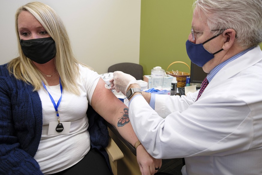 January 5, 2021, Urbandale, Iowa, U.S: Pharmacist JOHN FORBES right gives the Moderna GOVID-19 vaccine to LACEY MILLER, a hospital worker, at the Medicap Pharmacy in Urbandale. The pharmacy received a ...