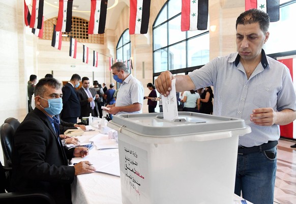 Ein Wähler gibt bei der Parlamentswahl in Syrien seine Stimme ab.