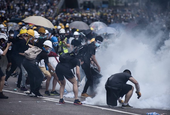 June 12, 2019 - Hong Kong - Protesters try to retreat through tear gas smoke canisters away from them during the demonstration..Thousands of protesters occupied the roads near the Legislative Council  ...