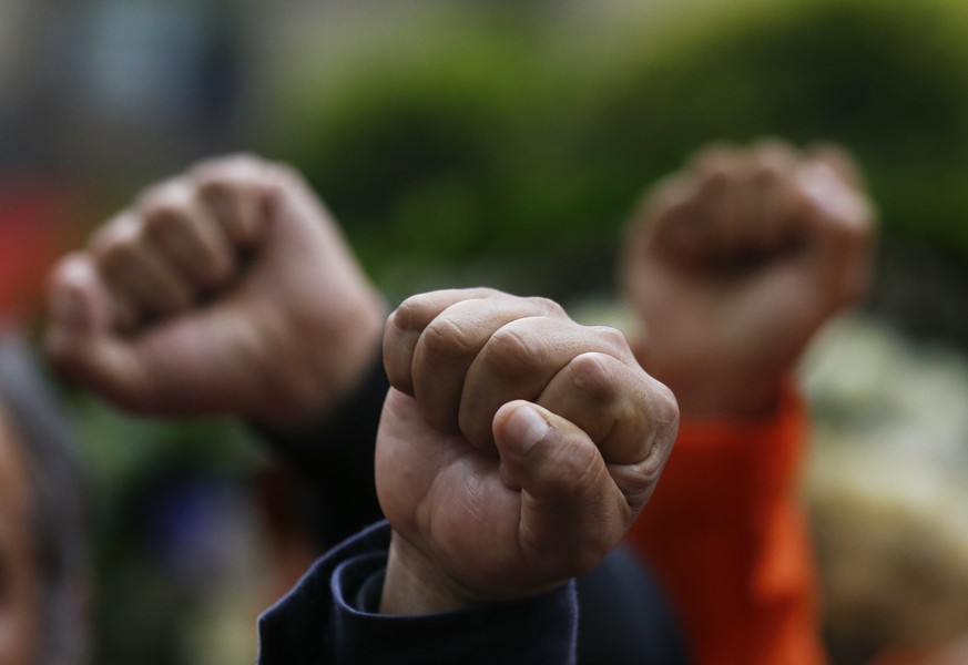 Rescue workers stand with with raised fists and in silence, in front of a 1985 earthquake memorial during a ceremony marking that quake&#039;s 33rd anniversary and last year&#039;s 7.1 magnitude earth ...