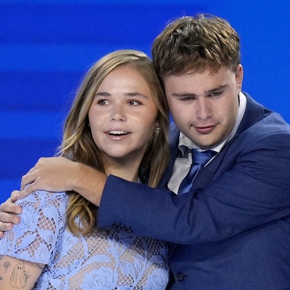 Hope Walz, left, and Gus Walz, children of Democratic vice presidential nominee Minnesota Gov. Tim Walz, right, hug after their father concludes a speech during the Democratic National Convention Wedn ...