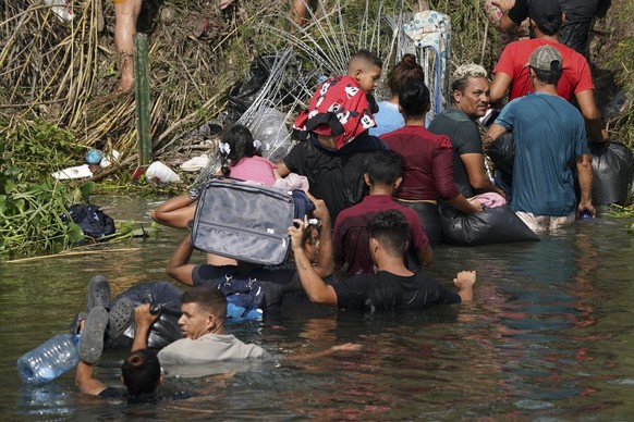 10.05.2023, Mexiko, Matamoros: Der venezolanische Migrant Luis Parra (3.v.r) überquert zusammen mit anderen Migranten den Rio Grande. Am 11. Mai fällt eine umstrittene Abschiebepraxis, die sogenannte  ...