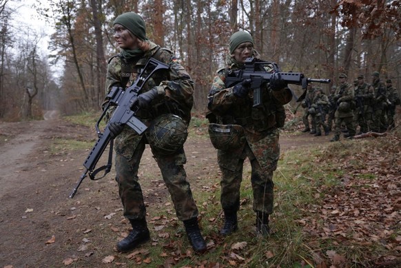 PRENZLAU, GERMANY - NOVEMBER 29: New female army (Heer) recruits of the Bundeswehr, Germany&#039;s armed forces, are armed with Heckler &amp; Koch G36 assault rifles as they lead a patrol in basic tra ...