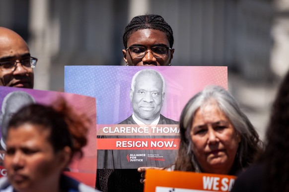 Congressmen call for resignation of Supreme Court Justice Clarence Thomas An activist holds a sign demanding Supreme Court Justice Clarence Thomas resign at a press conference that follows numerous in ...
