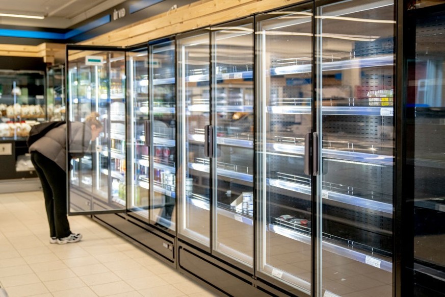 A customer looks at almost empty shelves in the supermarket FK in Torshavn, Faroe Islands, on June 7, 2024. Since May 14, 2024, truck drivers, port workers and several others have been on strike in th ...