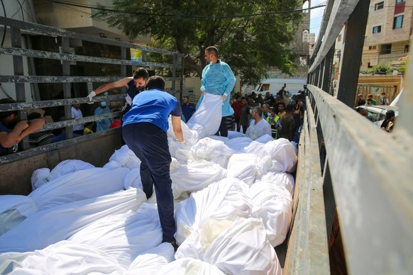 People carry out dead bodies of Palestinians, who lost their lives during the attacks of Israel, from the Shifa Hospital People carry out dead bodies of Palestinians, who lost their lives during the a ...