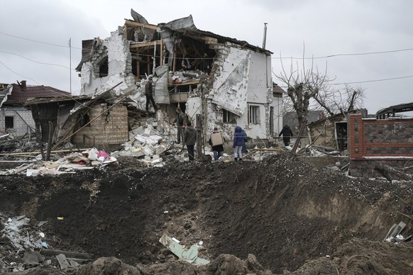 26.01.2023, Ukraine, Hlewacha: Ein Krater einer Explosion ist neben einem zerstörten Haus nach einem Raketenangriff zu sehen. Foto: Roman Hrytsyna/AP/dpa +++ dpa-Bildfunk +++