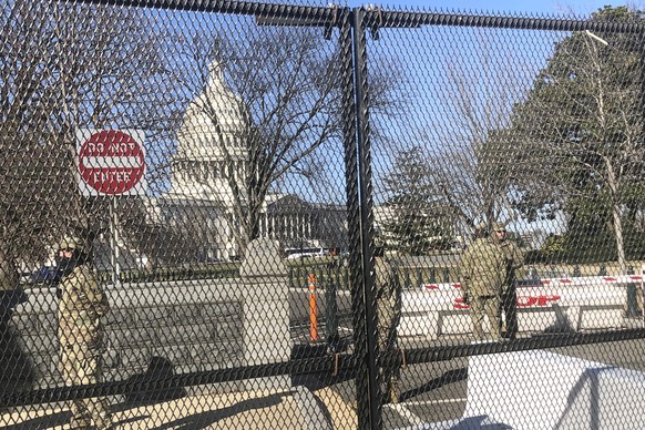 Members of the National Guard stand inside anti-scaling fencing that surrounds the Capitol, Sunday, Jan. 10, 2021, in Washington. Last week’s mob attack on the U.S. Capitol starkly highlighted a longs ...