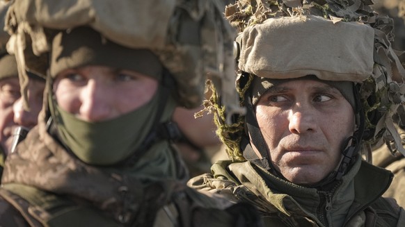 15.02.2022, Ukraine, Region Donezk: Ukrainische Soldaten stehen vor einer