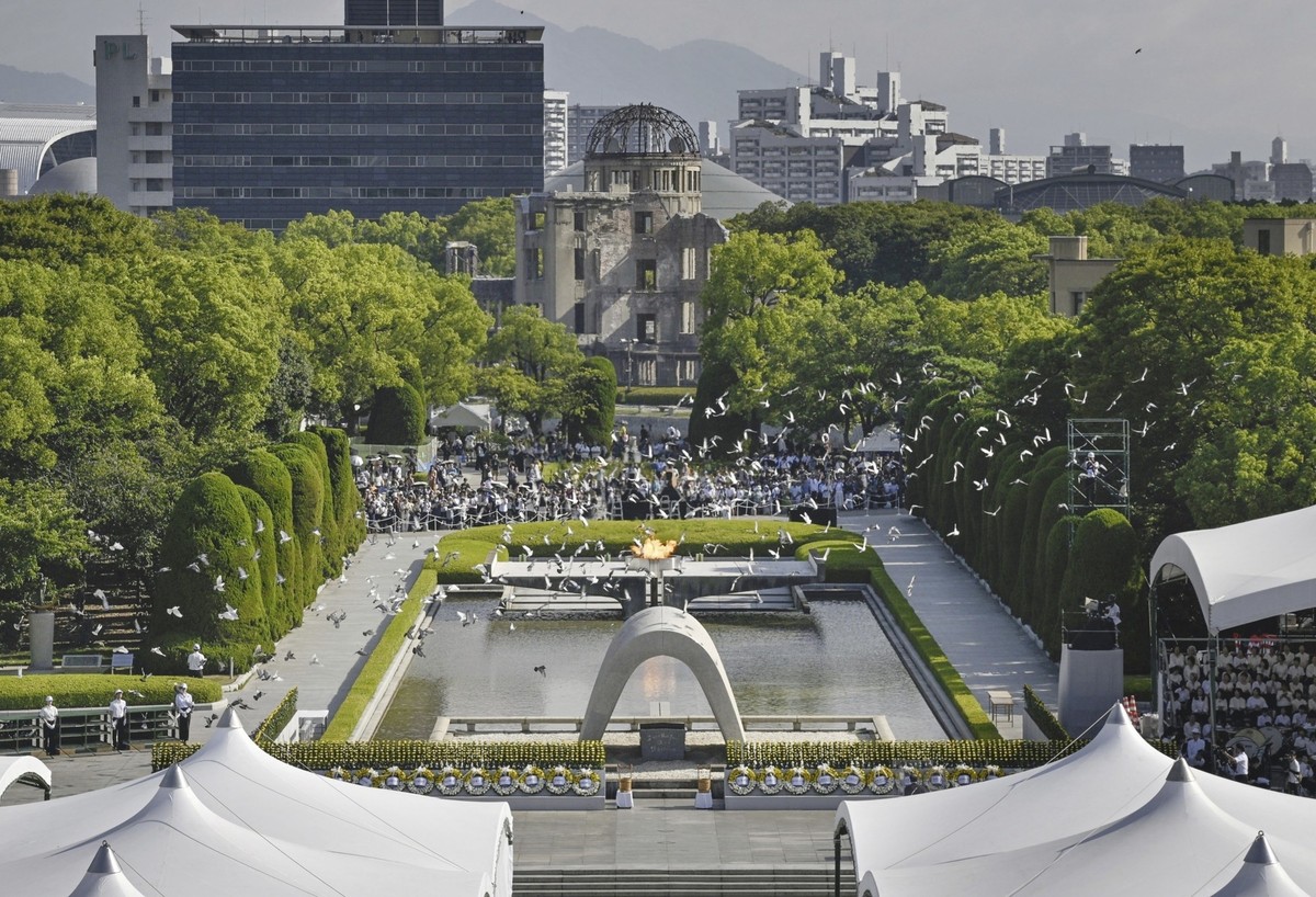 Doves fly over the cenotaph dedicated to the victims of the atomic bombing at the Hiroshima Peace Memorial Park during a ceremony to mark the 80th anniversary of the bombing in Hiroshima, western Japa ...