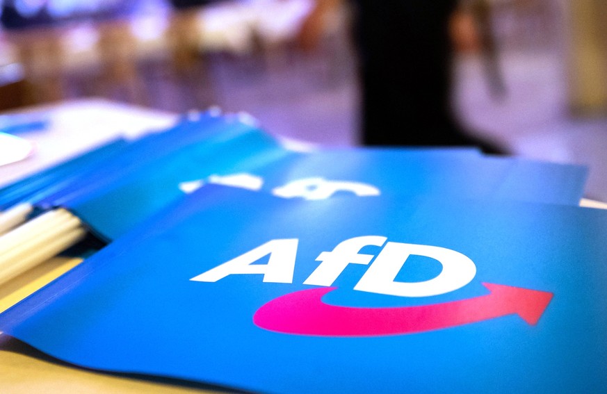 ARCHIV - 24.11.2018, Bayern, Greding: Fähnchen mit dem Logo der AfD liegen auf einem Tisch. (zu dpa: «Nazi-Parolen im Umfeld von AfD-Parteitag - Ermittlungen abgeschlossen») Foto: Daniel Karmann/dpa + ...