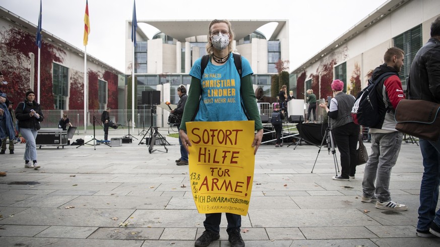 15.10.2022, Berlin: Eine Teilnehmerin der Kundgebung der Initiative #ichbinarmutsbetroffen steht mit einem Plakat mit der Aufschrift &quot;Sofort Hilfe für Arme&quot; am Bundeskanzleramt. #IchBinArmut ...