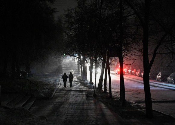 26.12.2022, Ukraine, Kiew: Menschen gehen bei starkem Schneefall eine dunkle Stra�e entlang. Foto: Sergei Chuzavkov/SOPA Images via ZUMA Press Wire/dpa +++ dpa-Bildfunk +++
