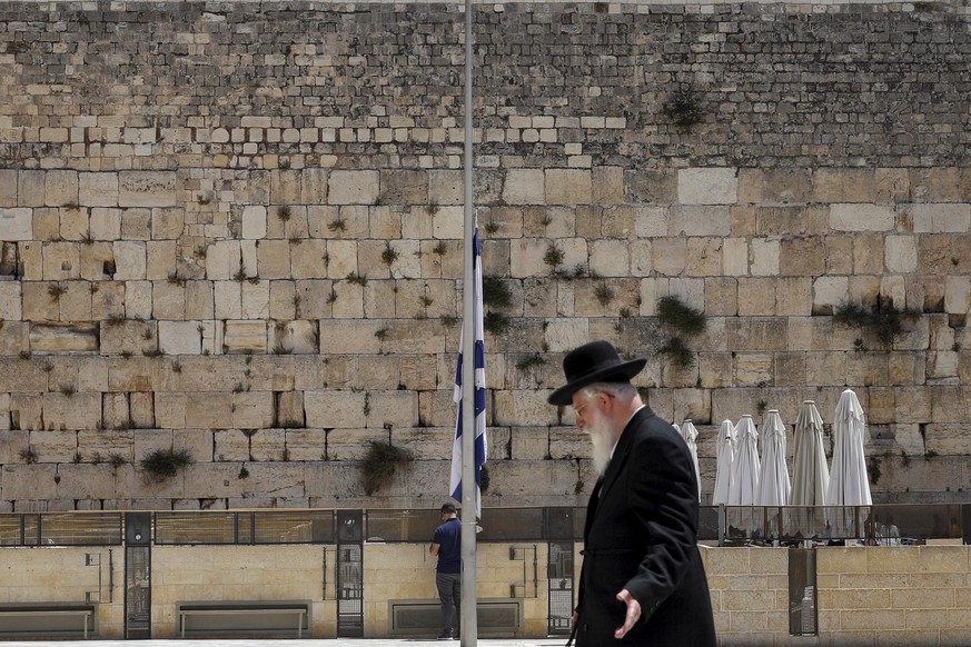 02.05.2021, Israel, Jerusalem: Eine israelische Nationalflagge vor der Klagemauer ist auf Halbmast gesetzt. Zwei Tage nach der Massenpanik mit 45 Toten an einem Wallfahrtsortauf dem Meron-Berg hat das ...