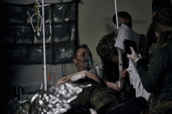 09.11.2022, Ukraine, Bachmut: Ein ukrainischer Soldat erh�lt erste Hilfe in einem Krankenhaus. Foto: Libkos/AP/dpa +++ dpa-Bildfunk +++