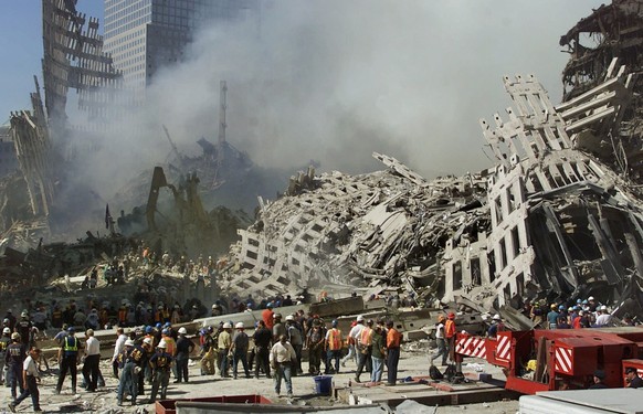 ARCHIV - 13.09.2001, USA, New York: Rettungskr�fte setzen ihre Suche nach Opfern fort, w�hrend Rauch aus den Tr�mmern des World Trade Center aufsteigt. Die Zwillingst�rme des World Trade Centers waren ...