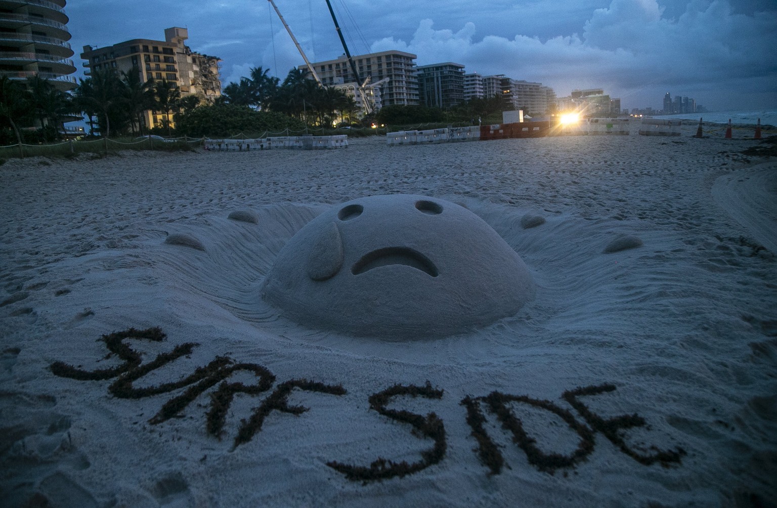 Am Strand von Surfside drückt diese Sand-Skulptur Trauer über das Unglück aus, bei dem ein großer Wohnkomplex teilweise einstürzte.