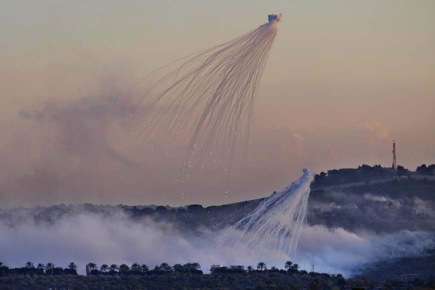 FILE - Shells that appears to be white phosphorus from Israeli artillery explode over Dahaira, a Lebanese border village with Israel, south Lebanon, on Oct. 16, 2023. The human rights group Amnesty In ...