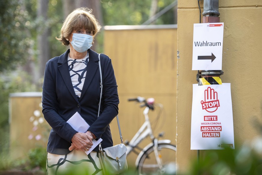 13.09.2020, Nordrhein-Westfalen, Köln: Mit Mundschutz wartet Henriette Reker (parteilos), Oberbürgermeisterin von Köln, vor dem Wahllokal, um ihre Stimme für die Kommunalwahl abzugeben. In Nordrhein-W ...