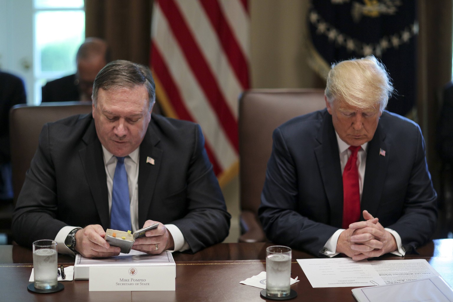 August 16, 2018 - Washington, District of Columbia, U.S. - United States Secretary of State Mike Pompeo, left, reads a prayer as he sits next to US President Donald J. Trump during a Cabinet Meeting i ...