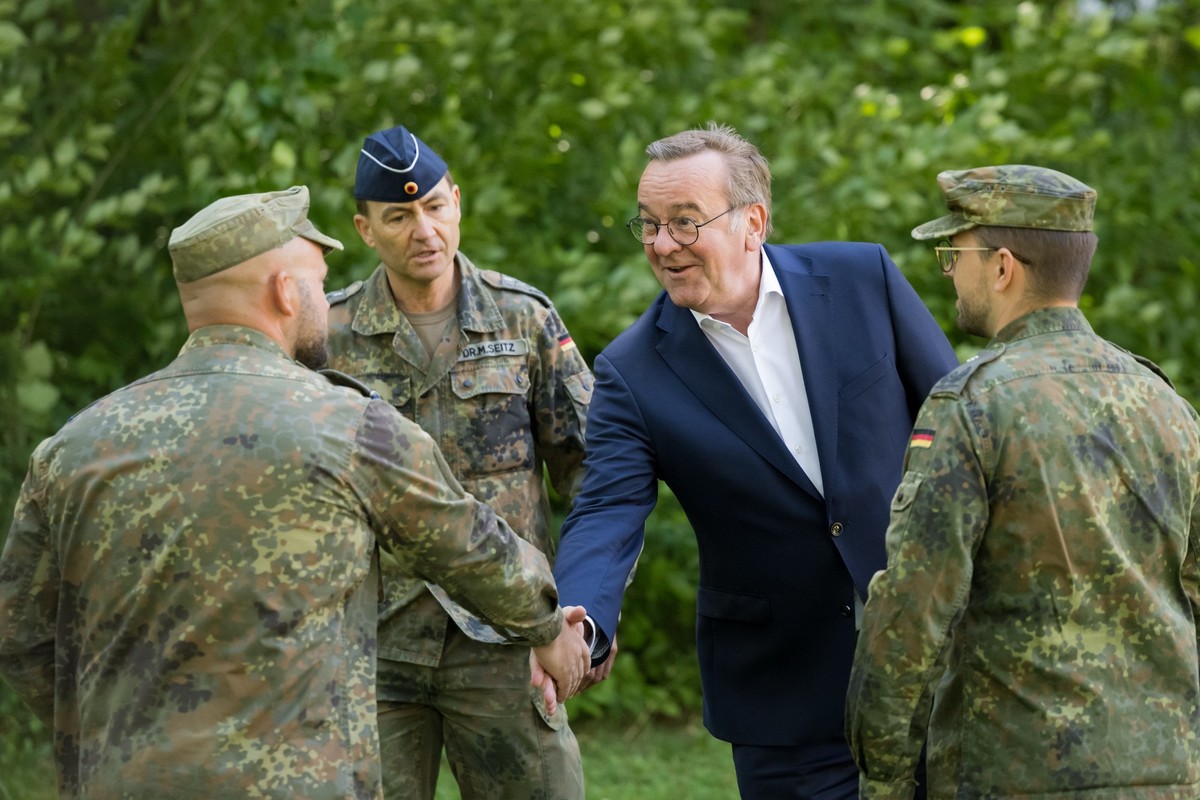 22.07.2025, Bayern, München: Bundesverteidigungsminister Boris Pistorius (2.v.r., SPD) begrüßt bei einem Besuch der Sanitätsakademie der Bundeswehr Soldaten. Gezeigt wird das mobile Labor des Institut ...
