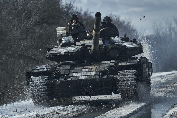 dpatopbilder - 20.02.2023, Ukraine, Bachmut: Ukrainische Soldaten fahren auf einem Panzer an der Frontlinie in Bachmut. Foto: -/Libkos/AP/dpa +++ dpa-Bildfunk +++