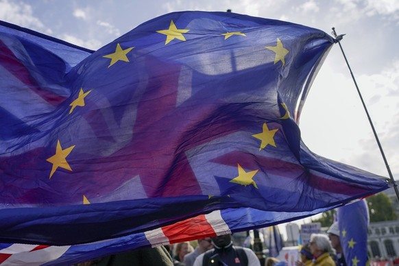 FILE - A Union flag waves behind a European Union flag, outside the Houses of Parliament, in London, Wednesday, Oct. 19, 2022. The British government on Sunday, Nov. 20, 2022 denied a report it is see ...