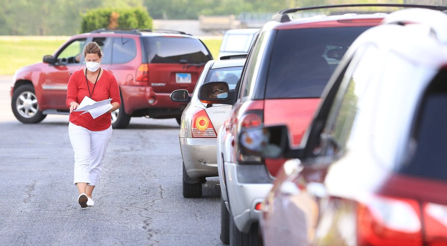 June 29, 2020, Rock Island, Iowa, USA: Sue McHugh with the Illinois Department of Health goes from car to car handing out paperwork for local residents to fill out before being tested for COVID-19 in  ...