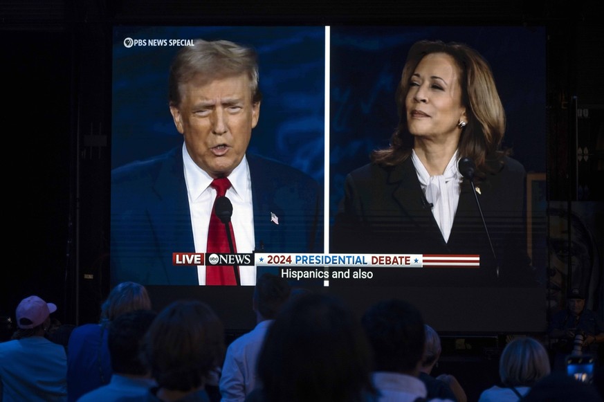 September 10, 2024, Philadelphia, Pennsylvania, USA: Former President DONALD TRUMP and Vice President KAMALA HARRIS are seen on a monitor as guests watch at the Harris-Walz campaign s Presidential Deb ...