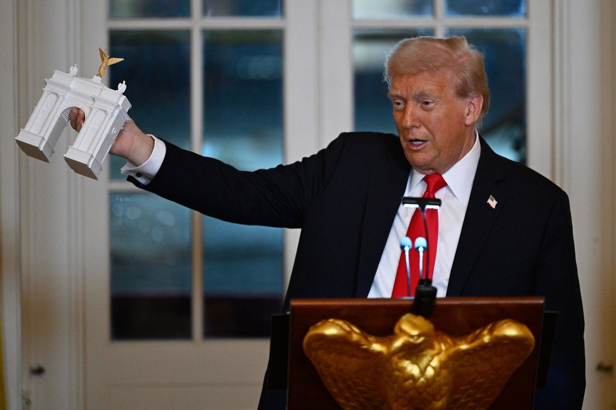 16.10.2025, USA, Washington: US-Präsident Donald Trump zeigt bei einem Abendessen für Spender, die zum Bau des neuen Ballsaals im Weißen Haus beigetragen haben, das Modell eines Triumphbogens. Foto: J ...