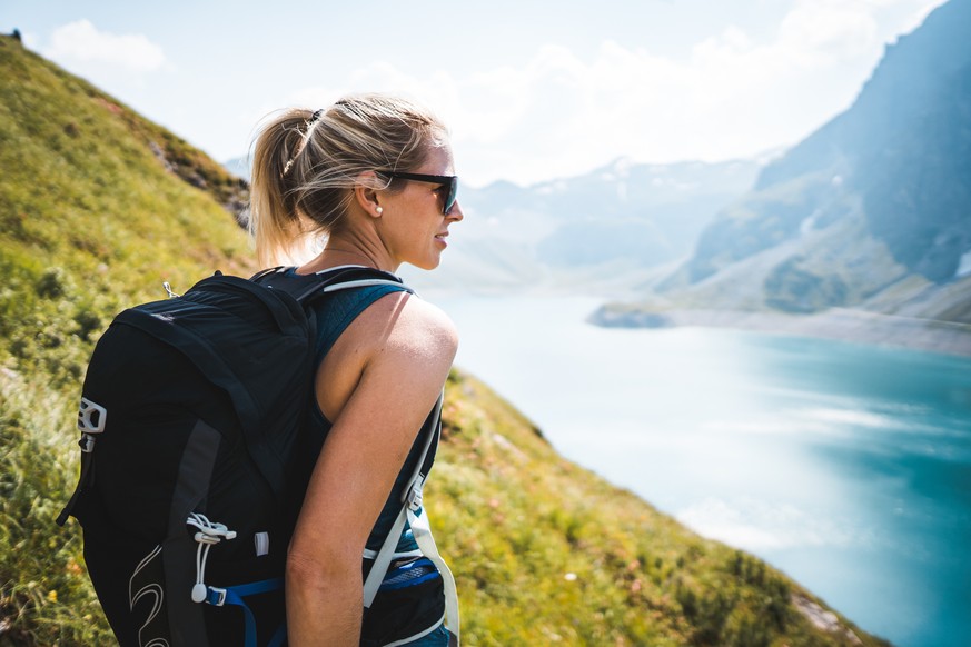 Adventurous Sportive Girl hiking at a Lake in Beautiful Alpine Mountains