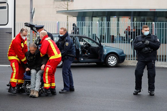 Firefighters attend a man who crashed with his car into the main gate of the chancellery in Berlin, the office of German Chancellor Angela Merkel in Berlin, Germany, November 25, 2020. REUTERS/Fabrizi ...