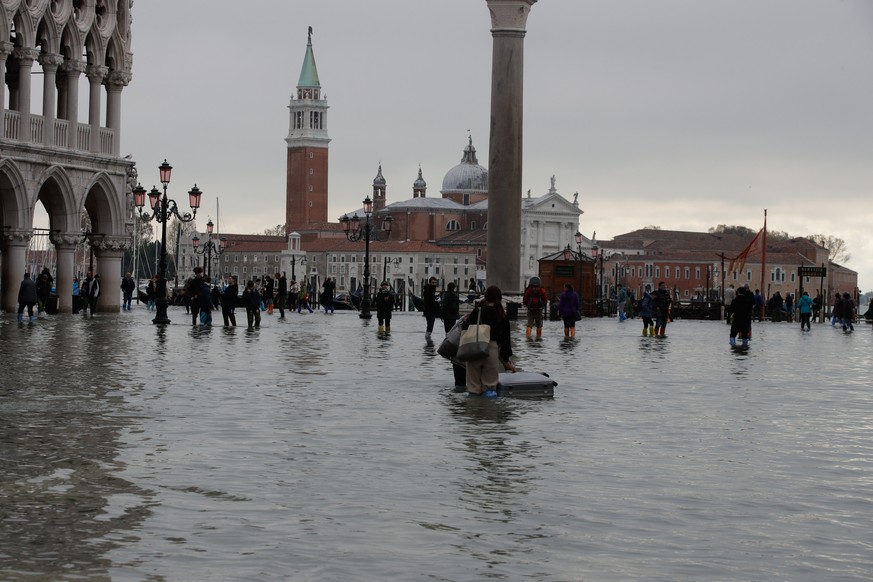 191114 -- VENICE, Nov. 14, 2019 Xinhua -- People walk across the flooded San Marco Square in Venice, Italy, Nov. 13, 2019. Residents of the flooded city of Venice are calling for an ambitious flood pr ...