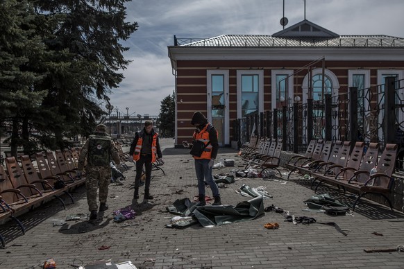 Freiwillige suchen nach Spuren, um die Leichen am Bahnhof Kramatorsk nach dem Raketenangriff zu identifizieren.