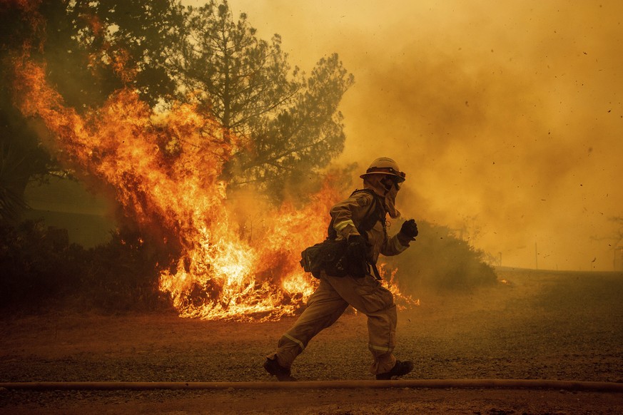 REMOVES NAME OF STREET AS STREET NAME IS UNKNOWN - A firefighter runs while trying to save a home as a wildfire tears through Lakeport, Calif., Tuesday, July 31, 2018. The residence eventually burned. ...