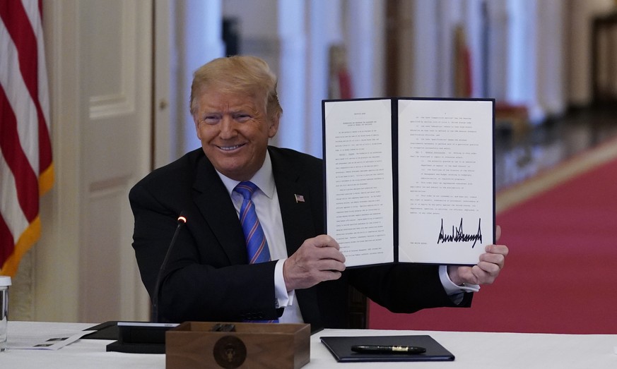 Ivanka Trump, right, applauds as President Donald Trump holds an executive order that he signed during a meeting with the American Workforce Policy Advisory Board, in the East Room of the White House, ...