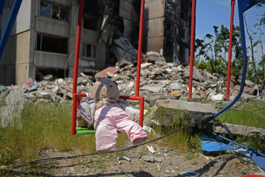 KHARKIV, UKRAINE - JUNE 2, 2022 - A teddy bear is left on a seat of a playground swing outside an apartment block destroyed by Russian shelling in the Pivnichna Northern Saltivka district of Kharkiv,  ...