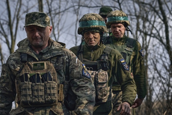 27.03.2023, Ukraine, Bachmut: Ukrainische Soldaten der 28. Brigade gehen gemeinsam an ihrer Position an der Frontlinie in der Nähe von Bachmut in der Region Donezk. Foto: Libkos/AP +++ dpa-Bildfunk ++ ...