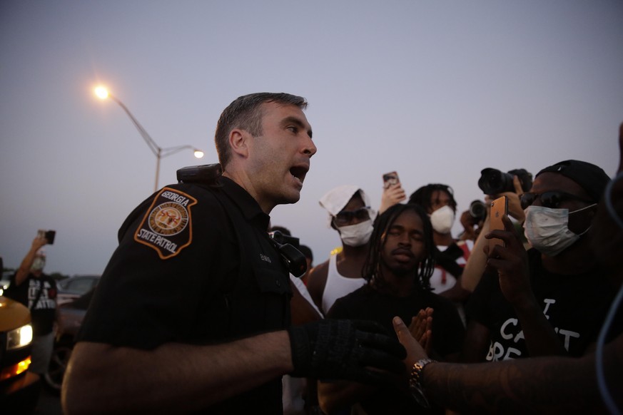 Ein Polizist spricht mit Demonstranten nach der Tötung eines Schwarzen in Atlanta durch die Polizei.