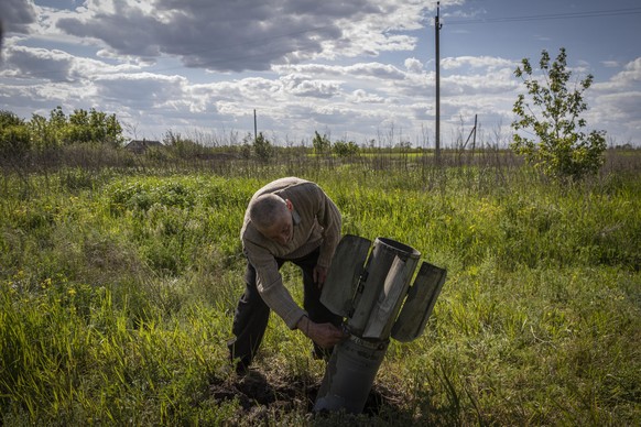 EIn Ukrainer checkt eine nicht explodierte russische Rakete im Donbas. 