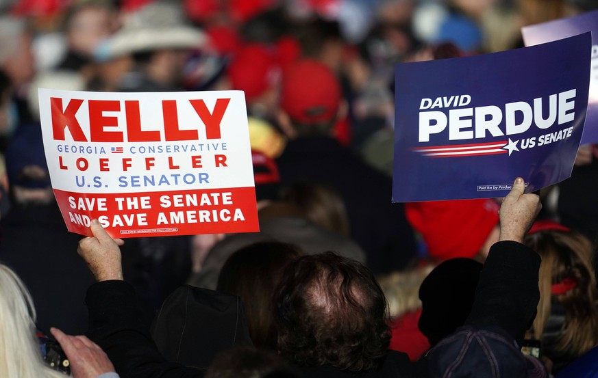 Supporter holds signs at Dalton Regional Airport for a Republican rally for Georgia Senators Kelly Loeffler and David Perdue in Dalton, Georgia on Monday, January 4, 2021. . PUBLICATIONxINxGERxSUIxAUT ...