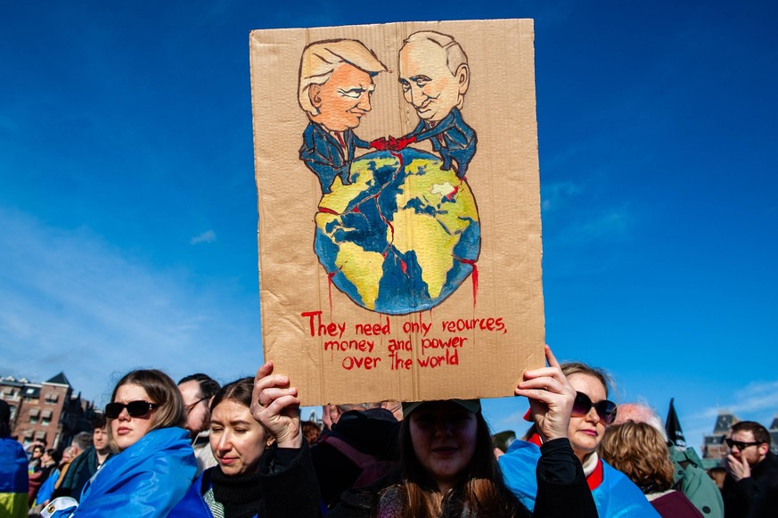 Three years of war in Ukraine demonstration held in Amsterdam, Netherlands - 23 Feb 2025 A view of an illustration of Putin and Trump running the world during the demonstration. In Amsterdam, thousand ...