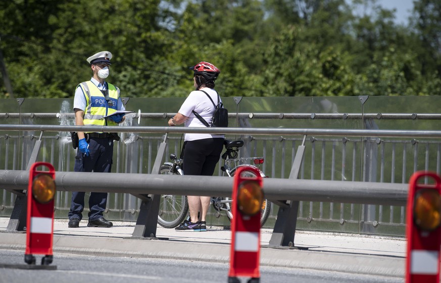 Grenzer,Polizeibeamter am Grenzuebergang. Spricht mit einer Radfahrerin. Grenzkontrollen an der Deutsch Oesterreichischen Grenze in Freilassing am 18.05.2020. Federal Minister of the Interior Horst Se ...