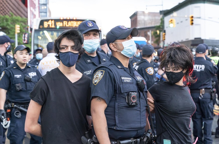 In New York nehmen Polizisten Demonstranten fest.