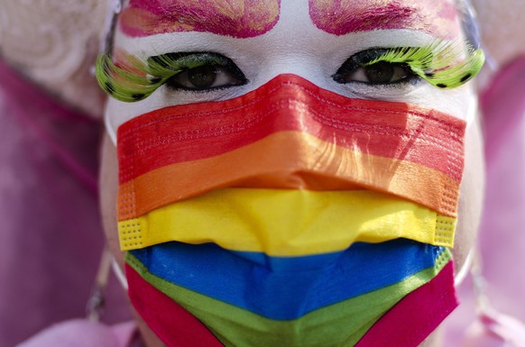 A person with a rainbow colored face mask attends a pride rally for visibility and freedom in Berlin, Germany, Saturday, June 26, 2021. More than one year after the outbreak of the corona pandemic, th ...